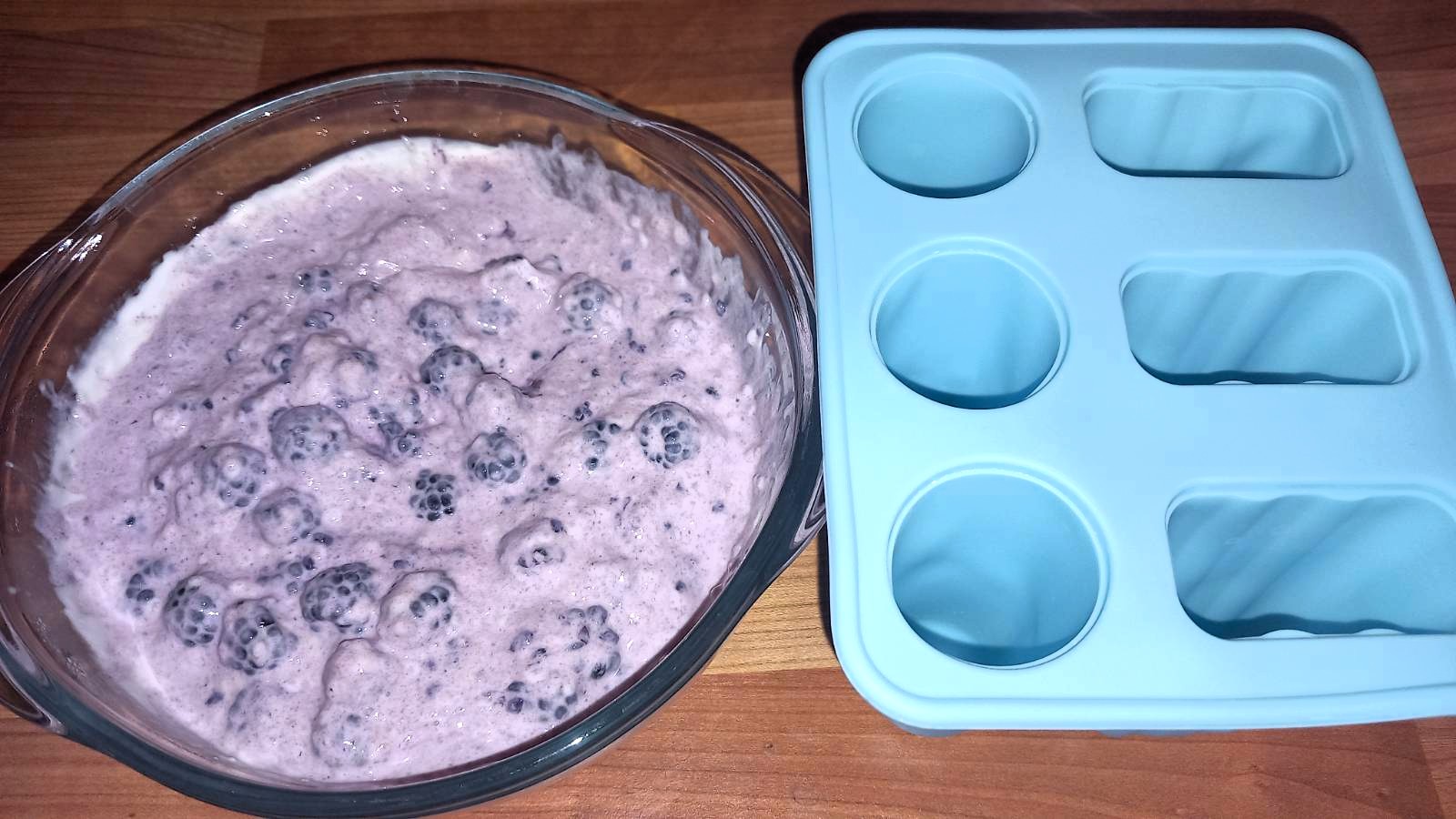 The mixture with crushed blackberries stirred through, next to the silicone mould